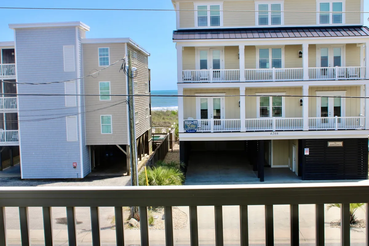 A sweeping view of the ocean from the building, with balconies overlooking the water and beach. The architecture of the condo is visible, and the setting exudes a relaxed, vacation vibe. The image suggests easy access to the shoreline and the promise of days spent by the sea.